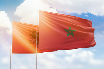 Sunny blue sky and flags of morocco and albania