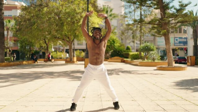 African american woman shirtless training jump exercise at park