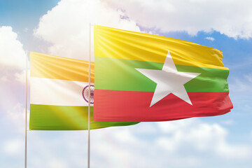 Sunny blue sky and flags of myanmar and india