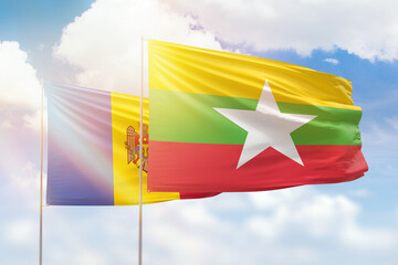 Sunny blue sky and flags of myanmar and moldova