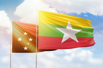 Sunny blue sky and flags of myanmar and papua new guinea