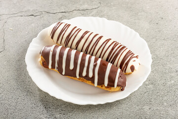 Eclair. Tasty chocolate eclair on the table.