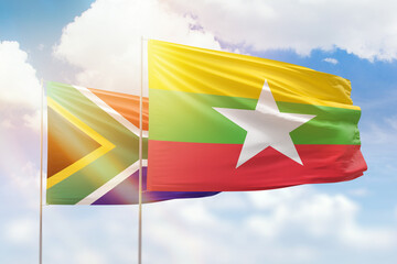 Sunny blue sky and flags of myanmar and south africa