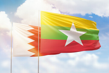 Sunny blue sky and flags of myanmar and bahrain