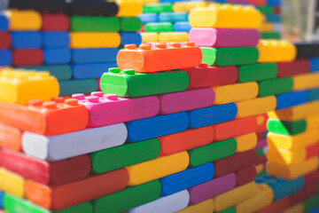 Children play colorful big toy blocks in kindergarten day care center playground, kids playing with...