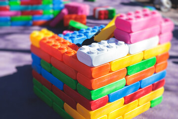 Fototapeta premium Children play colorful big toy blocks in kindergarten day care center playground, kids playing with various plastic mega construction blocks bricks