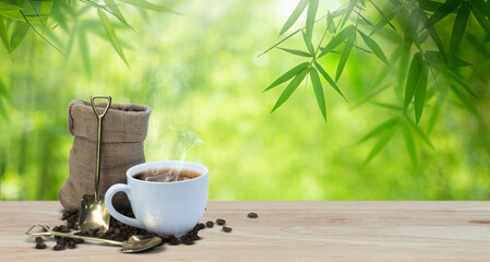 coffee cup and roasted beans in a bag on the table,backdrop of a  bamboo garden.