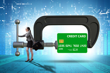 Concept of credit card debt with clamp and businesswoman