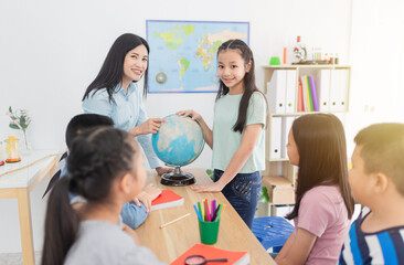 Fototapeta premium light and blur people, asian children students group learning about world map and history with female teacher, they feeling fun and happy in classroom, happiness elementary school