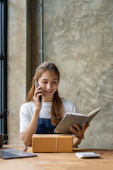 Asian SME business women use laptop computer checking customer order online shipping boxes at home. Starting Small business entrepreneur SME freelance. Online business, Work at home concept.