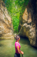 mujer en un arroyo entre rocas y cascadas