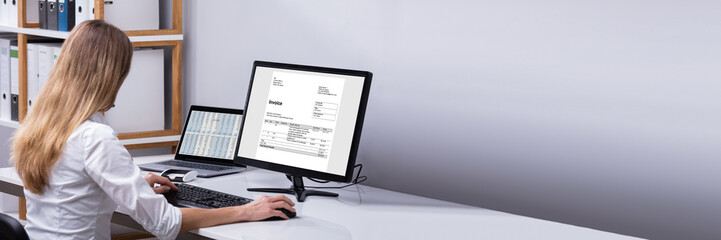 Businesswoman Checking Invoice On Computer