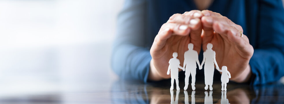 Businessperson's Hand Protecting Family Figures