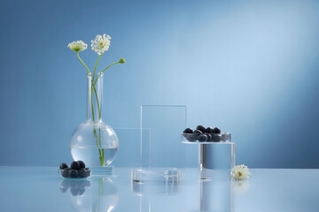 Front view of blueberry extract decorated with transparent podium and glassware blank space in blue background 