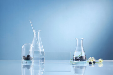 Front view of blueberry extract decorated with transparent podium and glassware blank space in blue...