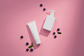 Top view of blueberry extract with transparent podium and cosmetic jar in pink background 