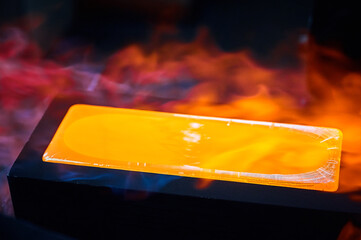 Hot gold ingot chills in casting form in shielding gases