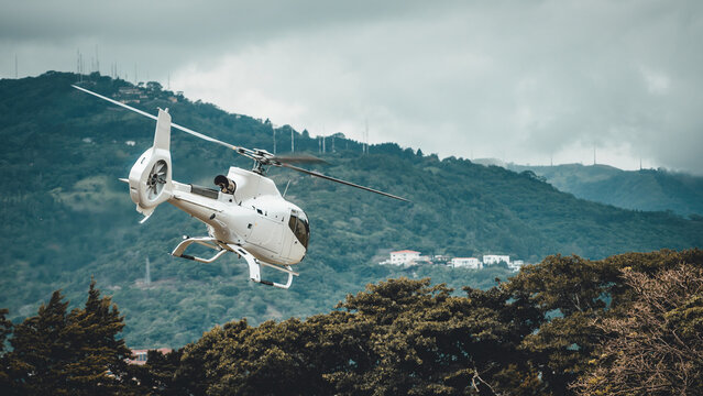 White helicopter flying mid-air