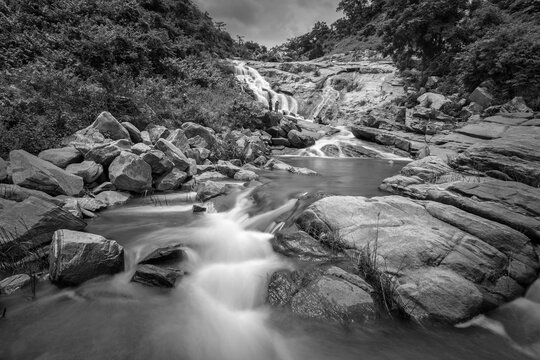 Beautiful Ghatkhola waterfall having full streams of water flowing downhill amongst stones , duriing monsoon due to rain at Ayodhya pahar (hill) - at Purulia, West Bengal, India. Black & White image.
