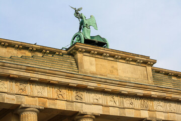 Quadriga bronze statue on top of Brandenburg gate or Brandenburger Tor in summer with clear blue sky background. No people.