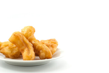 Deep-fried dough stick in white ceramic plate on a white background.