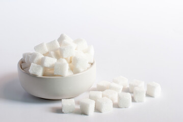 Fototapeta na wymiar Sugar cubes in a white bowl on white background.