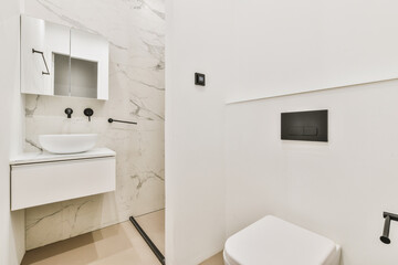 Modern flush toilet and ceramic sink installed on white tiled walls near mirror and towel in small...