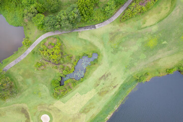 Aerial view drone shot of beautiful green golf field fairway and putting green Top down image for sport background and travel nature background Amazing view