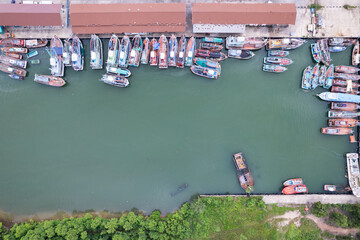 Fototapeta na wymiar Aerial top view of the many fisherman boats with big fishing port at the pier in Phuket Thailand. high angle view
