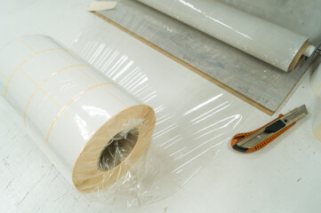 Packing rollers with self-adhesive white label in a transparent stretch film. Preparation of...