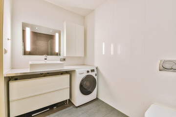 Modern flush toilet and ceramic sink installed on white tiled walls near mirror and towel in small...