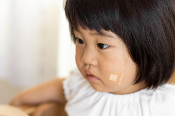 頬に絆創膏を貼った赤ちゃん（女の子、日本人、1歳11ヶ月）