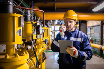 Refinery engineer standing by natural gas pipeline and controlling storage capacity of LNG terminal.