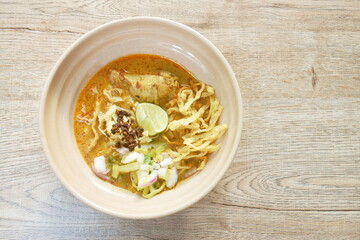 Thai northern style curry noodles in coconut milk soup with chicken on bowl