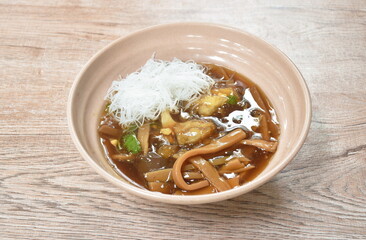 braised fish maw with bamboo shoot topping slice chicken and boiled egg in red gravy soup topping rice vermicelli on bowl