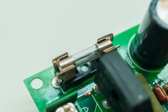 Hot melt fuse on electronic circuit board for high voltage protection. Electronics safety cartridge electrical fuse. PCB part. Selective focus