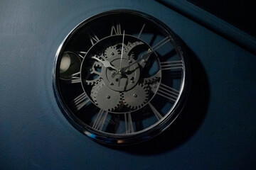 Big clock mounted on a dark blue wall. Time management concept.