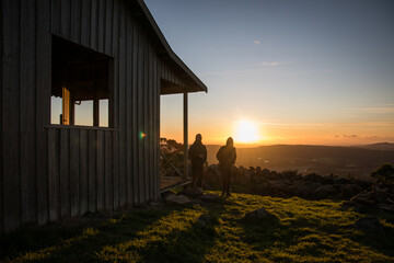 two men behind outdoors nature cabin hut sunset bush outback relaxed holiday watch view adventure travel friends