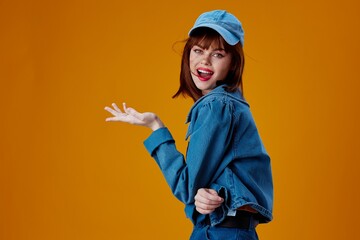 Pretty young female denim cap red lips glamor fashion yellow background unaltered