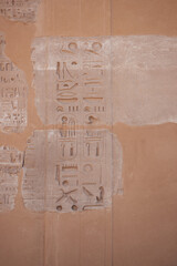 Real ancient Egyptian hieroglyphics engraved in a stone wall at Karnak Temple in Luxor Egypt