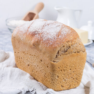 Loaf of homemade sandwich bread with white cloth, square format
