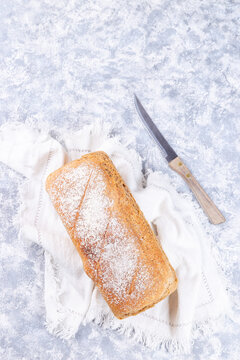 Loaf of homemade no knead sandwich bread with knife, vertical, top view, copy space