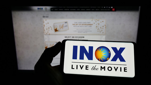 Stuttgart, Germany - 02-13-2022: Person Holding Cellphone With Logo Of Indian Cinema Company INOX Leisure Limited On Screen In Front Of Business Webpage. Focus On Phone Display.