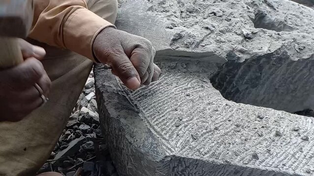 Indian Stone carving Artist Carving A Beautiful Abstract Sculpture From Black Granite Stone.