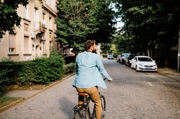 Young businessman rides a bicycle down the street.