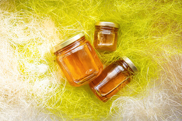 Fototapeta premium Honey in glass jars with flowers background.