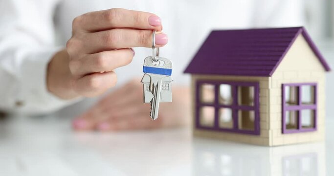 A woman's hand holds out the keys to the house