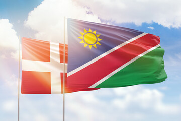 Sunny blue sky and flags of namibia and denmark