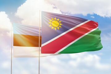 Sunny blue sky and flags of namibia and estonia
