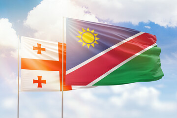 Sunny blue sky and flags of namibia and georgia